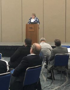 Woman speaks at a podium.