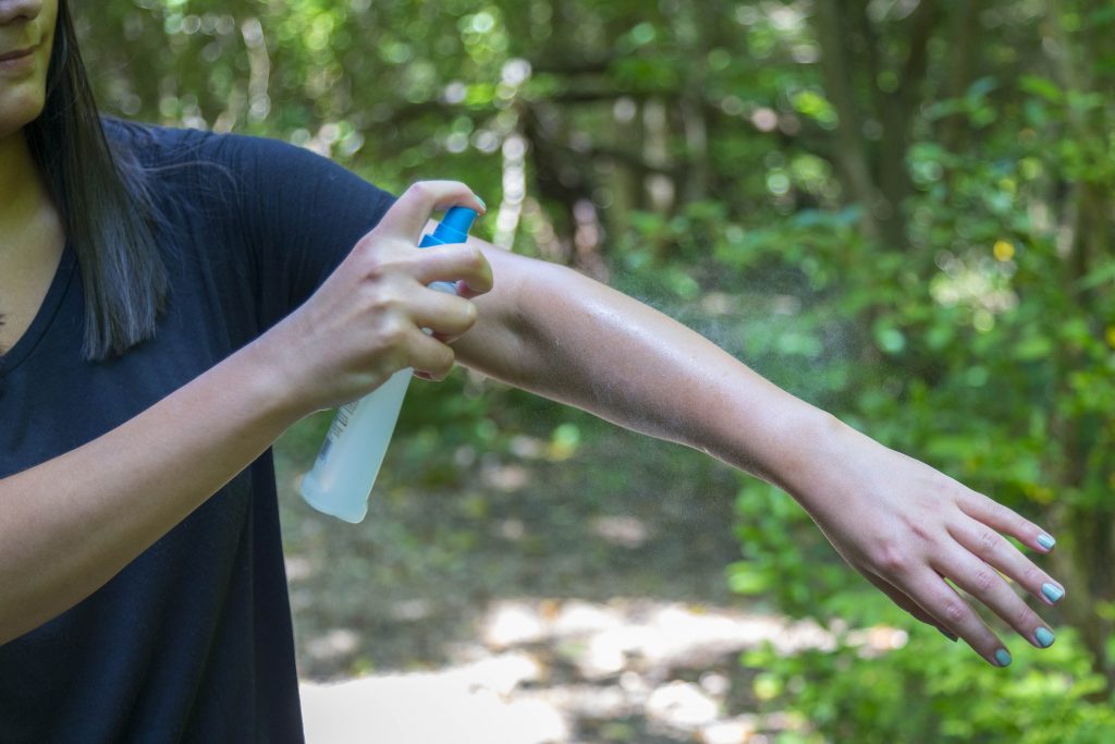 Woman applying bug spray