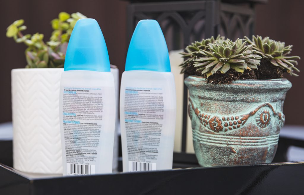 Bug spray bottles by a potted plant.